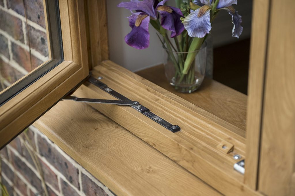 A stylish timber effect window featuring a flower vase on the sill, enhancing the home's inviting atmosphere. 