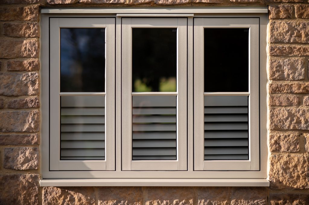 Cream Timberlook flush sash windows on a brick house